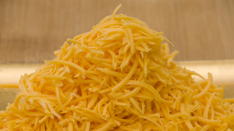 pile of grated cheddar cheese