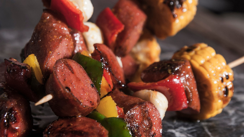 Hot dogs in skewer with corn and bell pepper