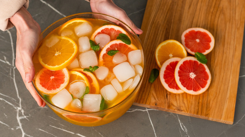 Person holding a bowl of fruit punch