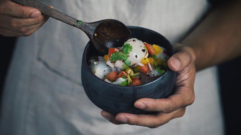 Person holding a bowl of lychee salsa
