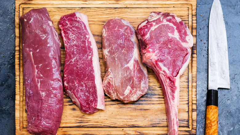 cuts of steak on wooden board