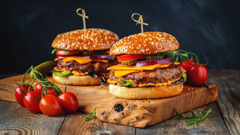 two burgers on wooden board