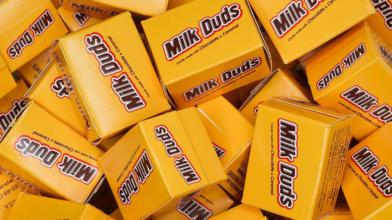 pile of mini Milk Duds boxes
