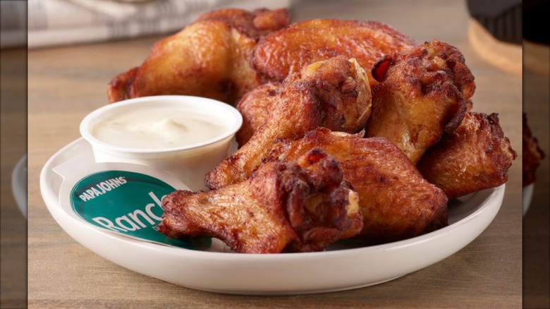 Pile of Papa John's traditional wings in a curved, white plate