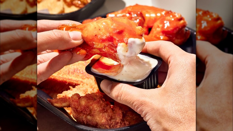 Zaxby's bone-in wing being pulled out of dipping sauce