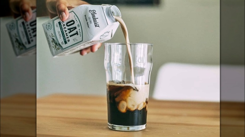 pouring elmhurst creamer into coffee