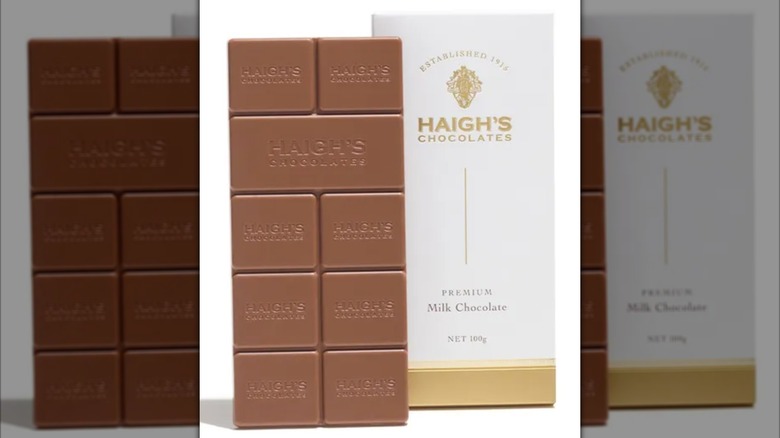 A bar of Haigh's Premium Milk Chocolate is shown on top of its wrapper.