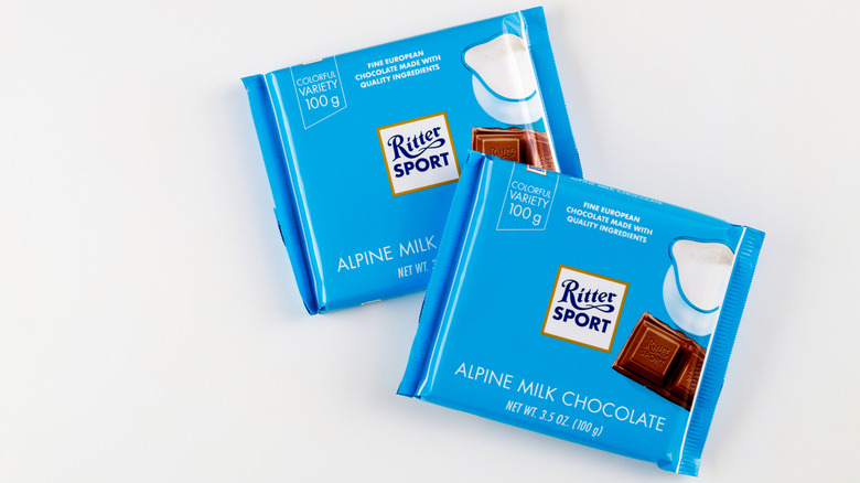 Two bars of Ritter Sport Alpine Milk Chocolate are set on a grey background.