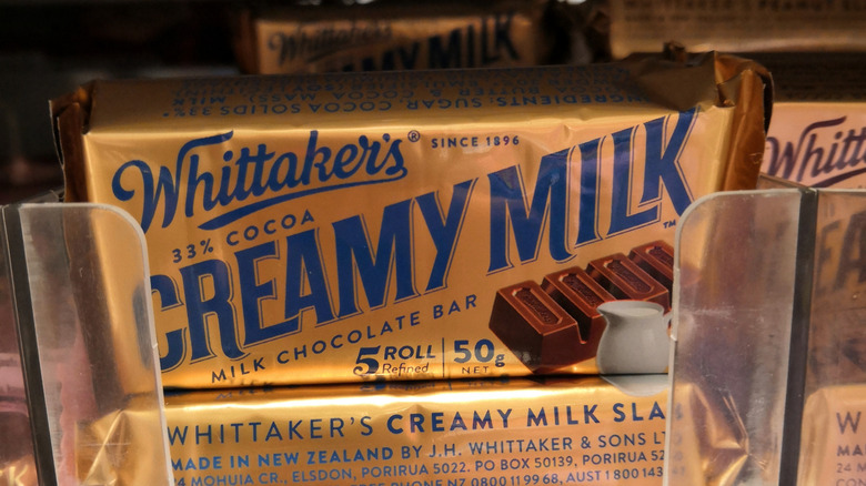 A bar of Whittaker's Creamy Milk chocolate is sitting on a supermarket shelf.