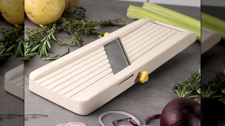 Benriner mandoline vegetable slicer next to herbs and onions
