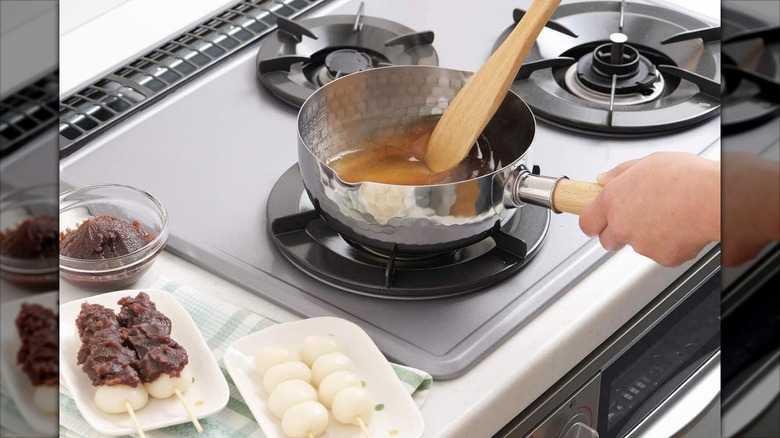 Yoshikawa Yukihira hammered saucepan on a stove next to kebabs