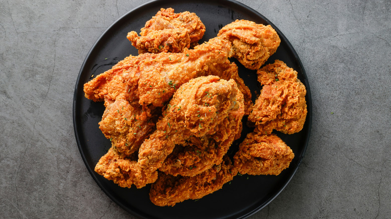 Pieces of fried chicken on a black plate