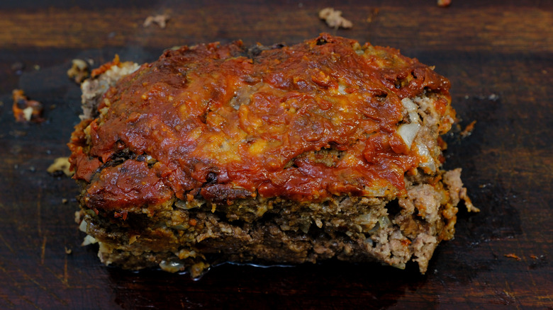 A slice of meatloaf on cutting board