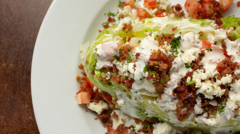 A close up of a wedge salad in a white dish