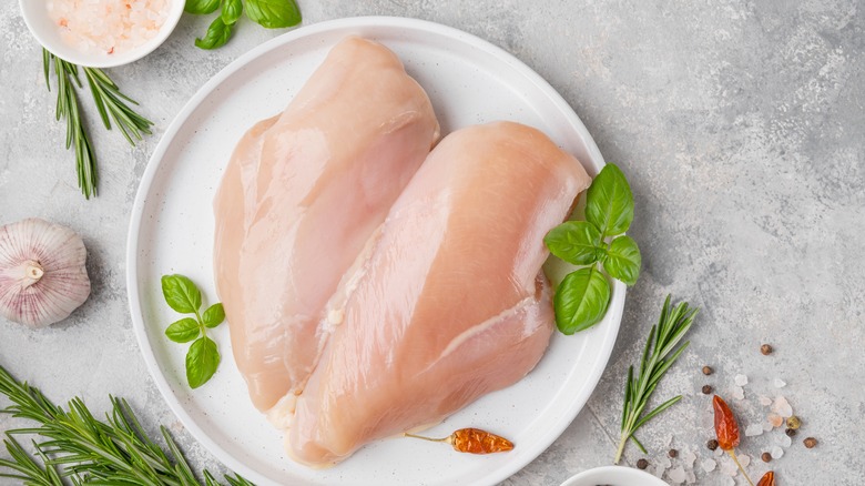 raw chicken with fresh herbs