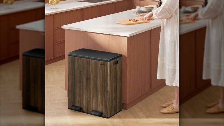 Dual compartment trash can sits by counter
