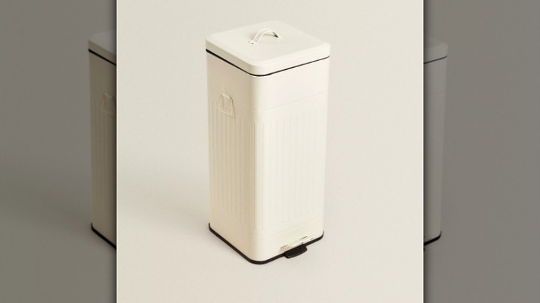 Retro trash can on beige background