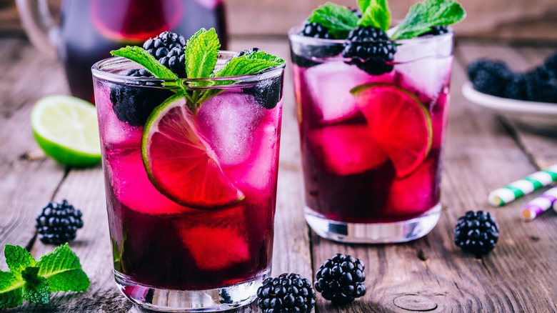 Two tumblers of blackberry lemonade cocktails