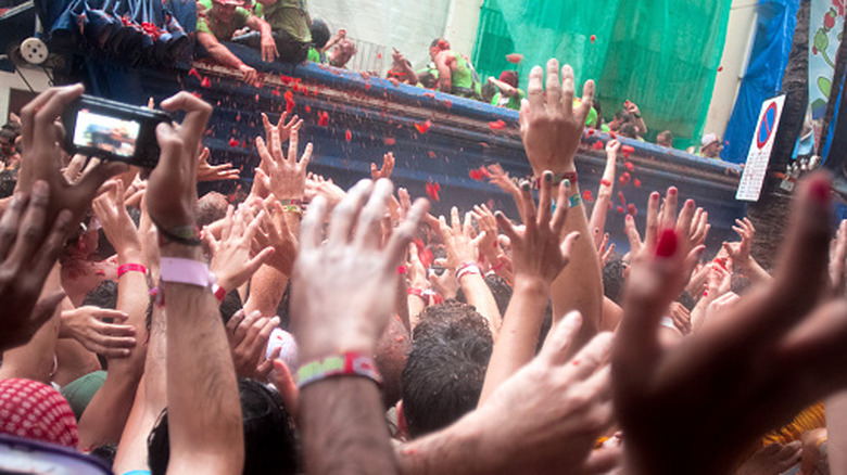 men in pile of tomatoes