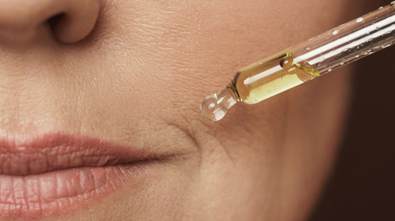 female face olive oil dropper