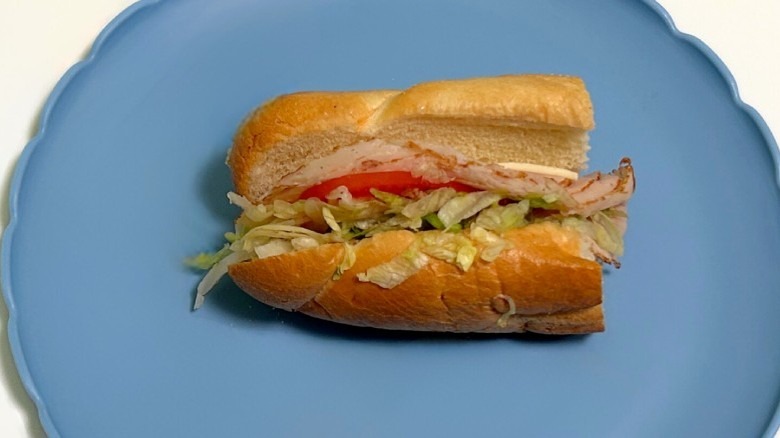 A Wawa turkey hoagie on a blue plate against a white background