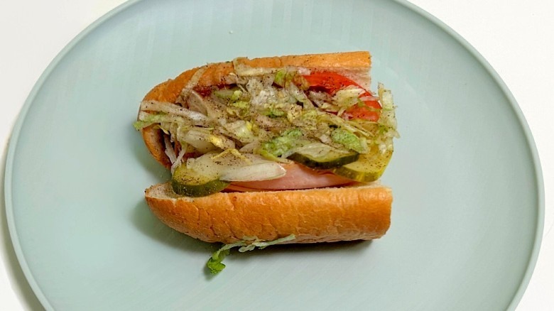 A Wawa BBQ turkey hoagie on a green plate against a white background