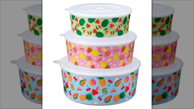 Product image of the Crofton nesting bowls or colander bowls with patterns featuring watermelon against a green background, lemons and strawberries against a pink background, and assorted tropical fruits against a light blue background.