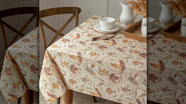 Autumnal leaf tablecloth on table with tableware