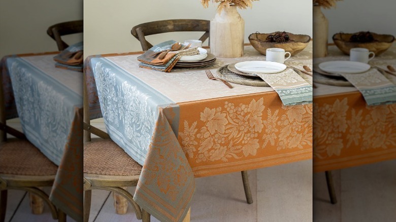 Orange and blue fall tablecloth with plates and decor