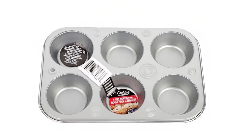 Metal muffin tin with six slots on white background.