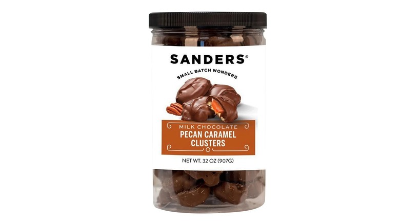 Jar of chocolate pecan clusters on white background