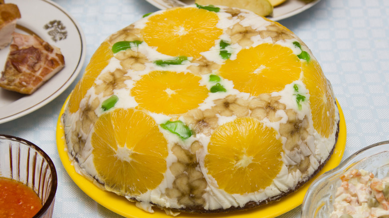 A Jell-O salad with orange slices and green Jell-O set on a table