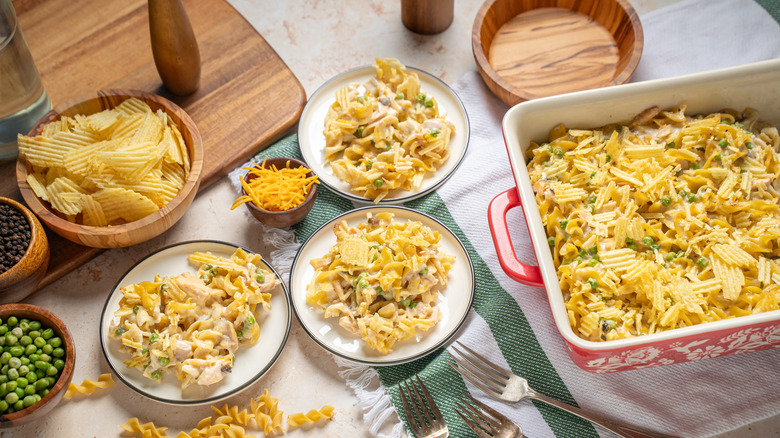 A retro table setting with plates of tuna casserole garnished with potato chips