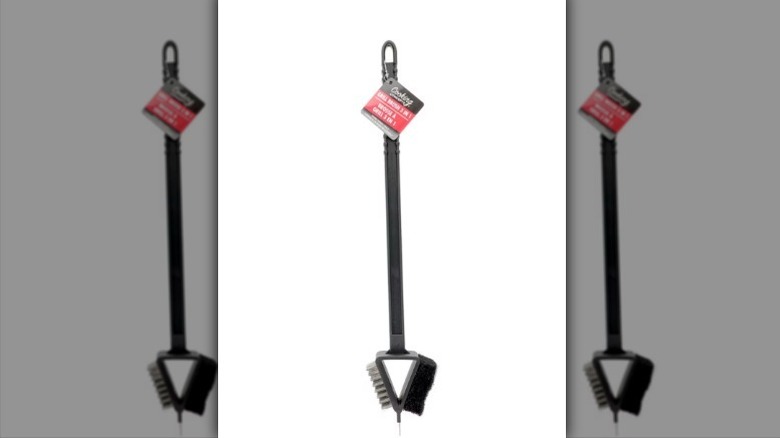 Grill brush with a black and red tag hanging from the handle on white background