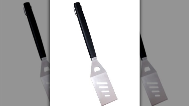 BBQ spatula with metal spatula and black handle on white background