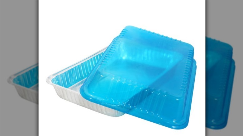 Aluminum cake pan with clear blue lid on white background