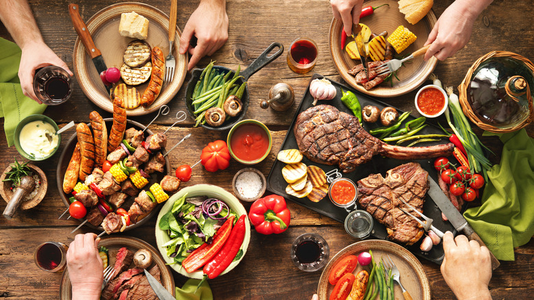 Overview of grilled meats and veggies on table