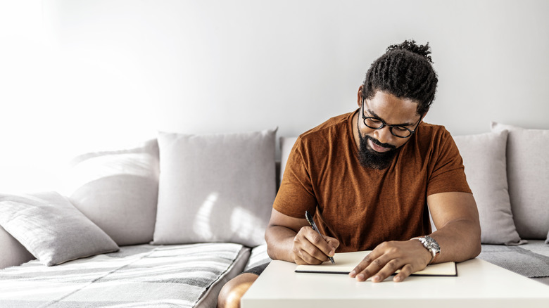 man writing in planner