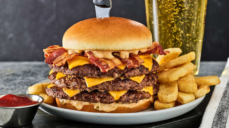 A Three Pointer Buzzer Beater Bacon Cheeseburger with fries and a beer