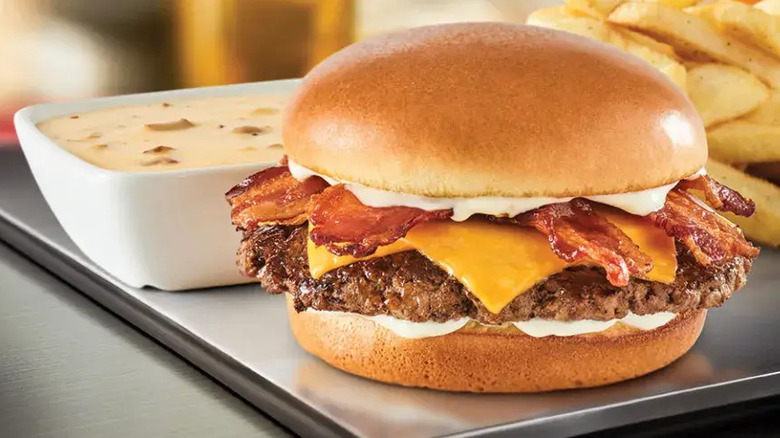 Red Robin Cheesy Bacon Fondue Burger on plate with bowl of fondue and fries
