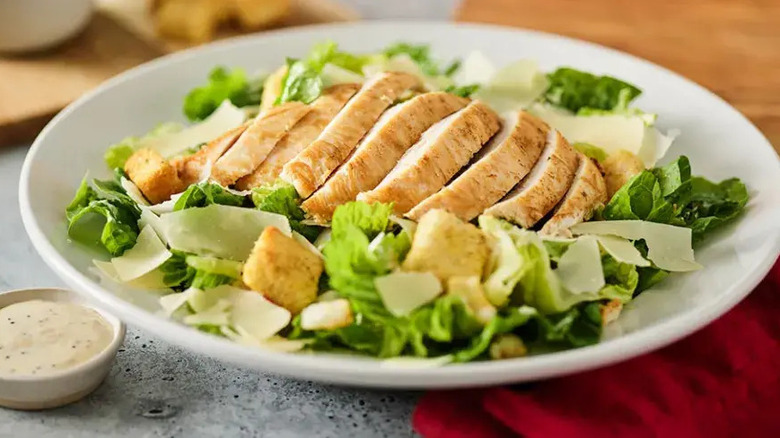 A chicken Caesar salad with side of dressing from Red Robin