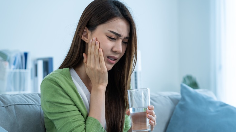 woman in pain holding face