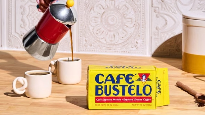 Cafe Bustelo Ground Espresso Coffee brick with coffee maker and two coffee cups in the background