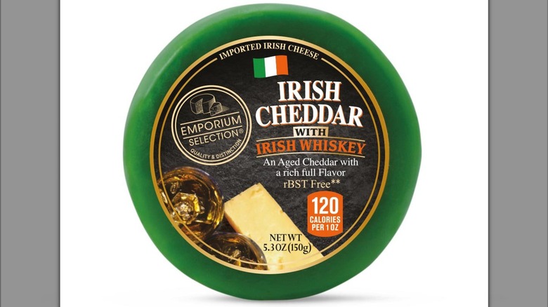 5-ounce wheel of Emporium Selection Irish Cheddar with Irish Whiskey against white background.