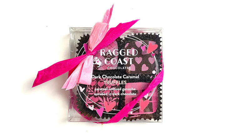 Pink dark chocolate caramel truffles box on white background