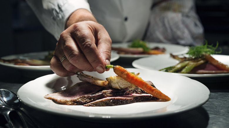 Chef plating a carrot