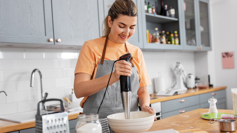 Woman using an immersion blender