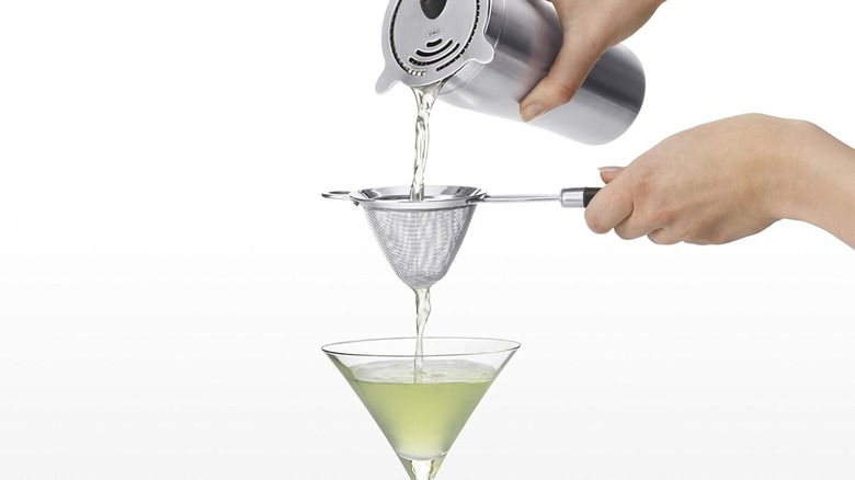 Pouring a cocktail through the OXO fine mesh strainer and into a martini glass