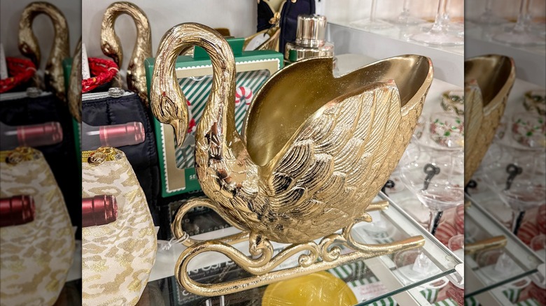 A gold-colored decorative sleigh that's also a goose statuette