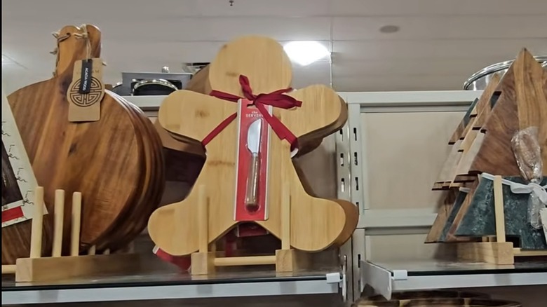A wooden serving board shaped like a gingerbread man, with an included cheese knife